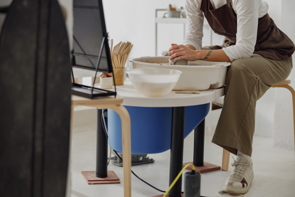 Close up of artisan's hands shaping clay bowl in pottery studio. Pottery art and creativity